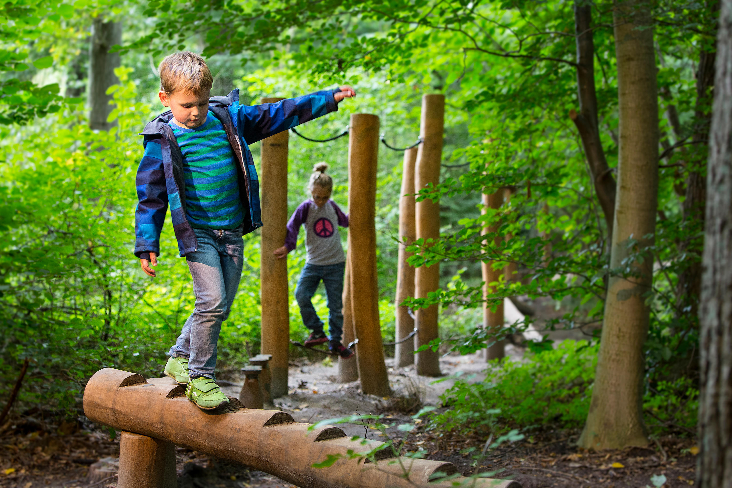 Play natural. Child playing on Outdoor Playground in Rain. Play outdoors Label. Resolved with Hags. Exploring nature and playing in Water.