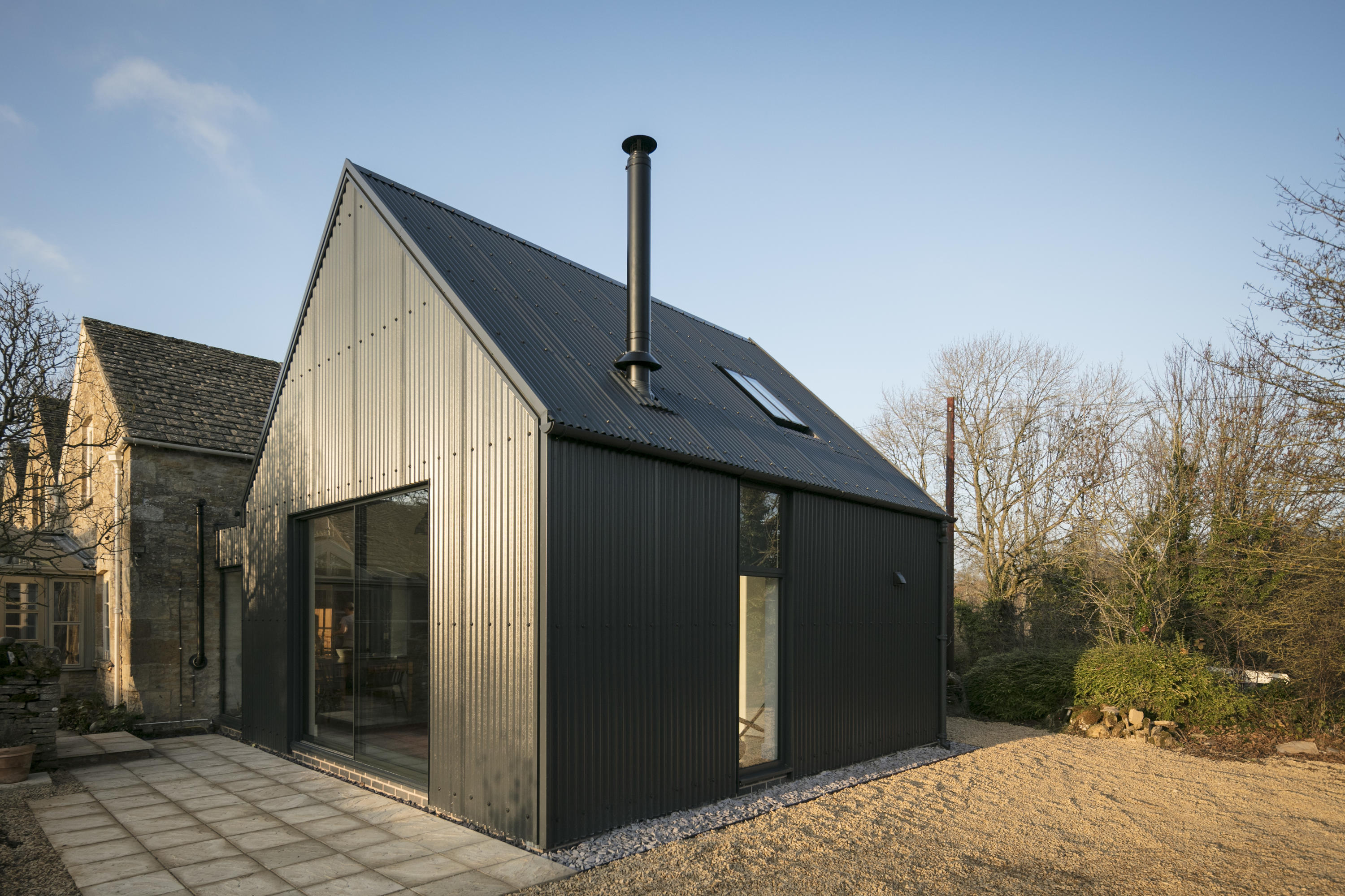 Corrugated metal extension by Eastabrook Architects Detached houses