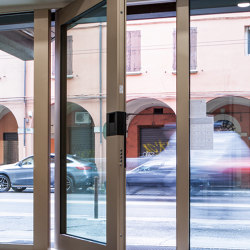 Nova | Die verglaste Sicherheitstür mit Drehvorrichtung, die es gestattet, Eingangsbereiche jeder Größe zu schaffen. |  | Oikos – Architetture d’ingresso