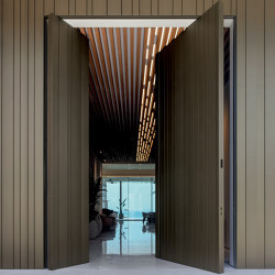 Synua | La porta blindata per le grandi dimensioni con funzionamento a bilico verticale e complanare al muro. | Entrance doors | Oikos – Architetture d’ingresso
