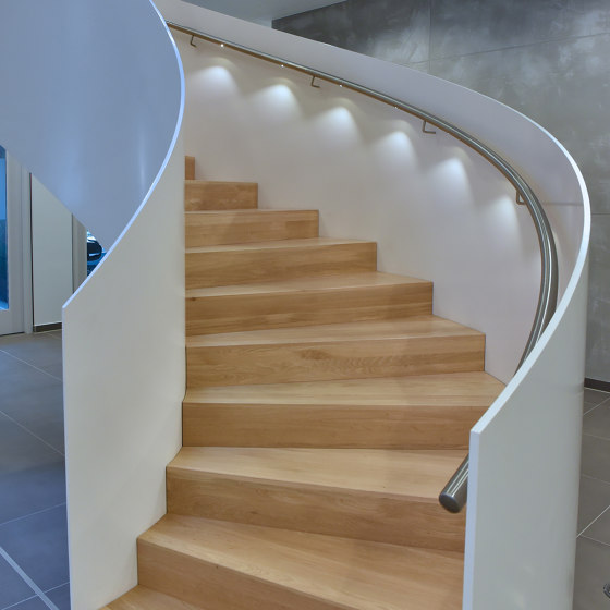 Eindrucksvoll gerundete Wangentreppe mit LED-Handlaufbeleuchtung in der Norderstedter Bank | Treppensysteme | MetallArt Treppen