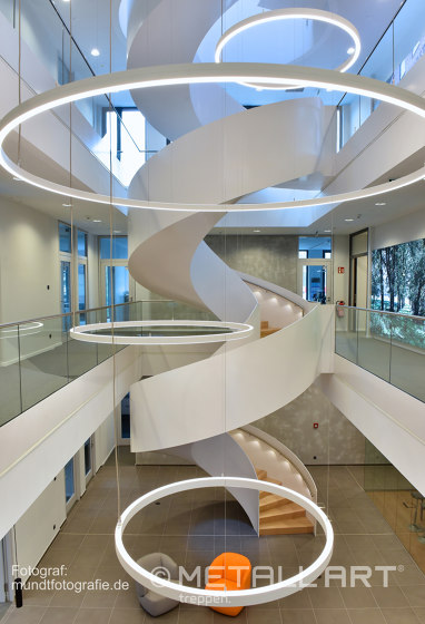 Impressively rounded stringer stairs with LED lighting at Norderstedt Bank | Scale | MetallArt Treppen