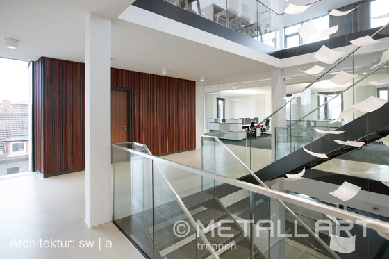 Stylish steel stairs featuring all-glass railings at WMD in Ahrensburg | Pasamanos | MetallArt Treppen