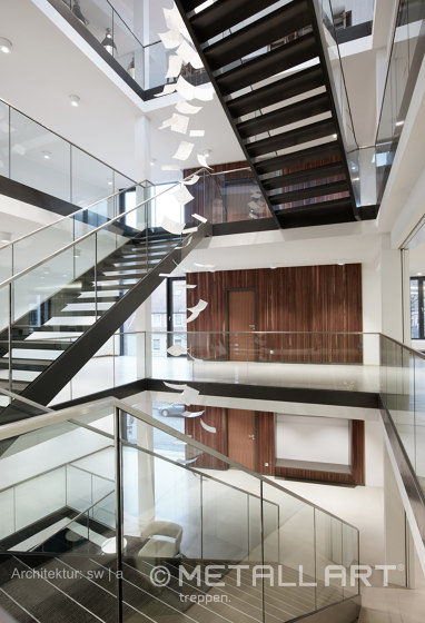 Stylish steel stairs featuring all-glass railings at WMD in Ahrensburg | Pasamanos | MetallArt Treppen