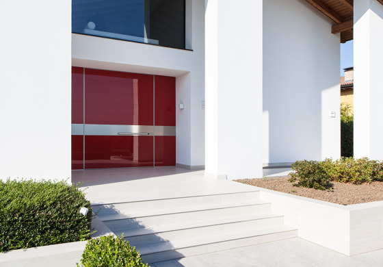 Synua | Porta blindata a bilico verticale con rivestimento in vetro lucido | Porte casa | Oikos Venezia – Architetture d’ingresso