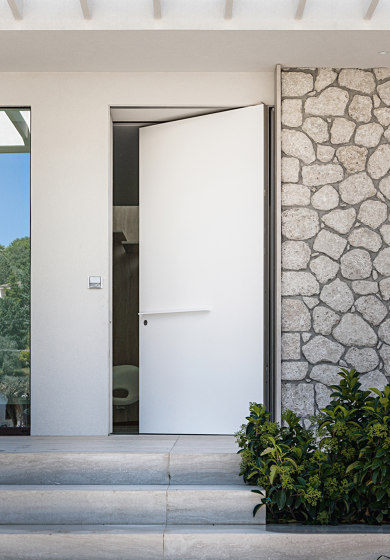 Synua | The safety door for large dimensions, with vertical pivot operation and installation coplanar with the wall. | Entrance doors | Oikos – Architetture d’ingresso
