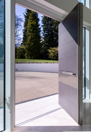 Synua | La porta blindata per le grandi dimensioni con funzionamento a bilico verticale e complanare al muro | Porte casa | Oikos – Architetture d’ingresso