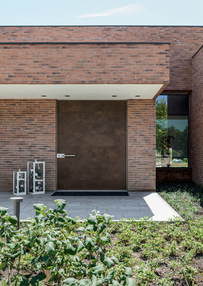 Synua | La porte blindée pour les grandes dimensions, avec fonctionnement
pivotant vertical et coplanaire au mur. | Portes d'entrée | Oikos Venezia – Architetture d’ingresso