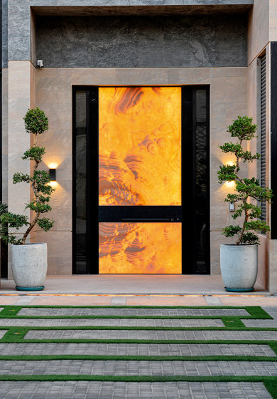 Synua | Puerta de seguridad pivotante con revestimiento personalizado en Ónice Arco Iris retroiluminado | Puertas de las casas | Oikos – Architetture d’ingresso