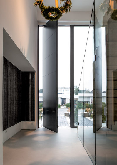 Synua | La porta blindata per le grandi dimensioni con funzionamento a bilico verticale e complanare al muro. | Porte ingresso | Oikos Venezia – Architetture d’ingresso